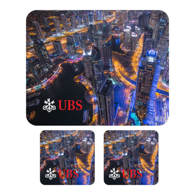 A mouse mat and two coasters featuring a vibrant city skyline in blues and yellows, with a logo on each item.