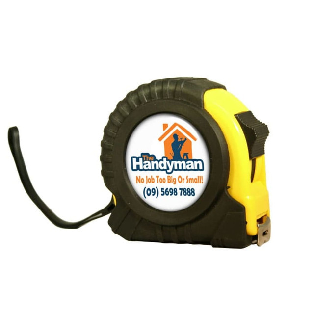 A yellow and black dome tape measure with a logo on the front, featuring a sturdy design and a measuring tape.