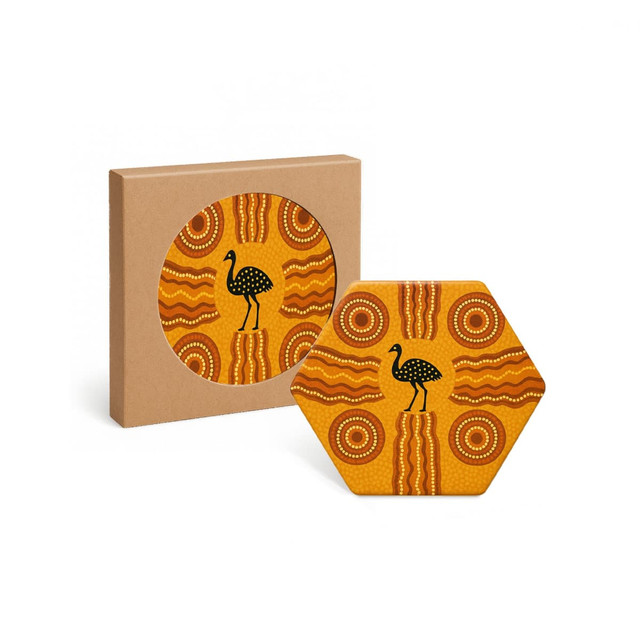 A hexagon ceramic coaster in vibrant orange, featuring a design with dotted patterns and a black bird silhouette, in a box.