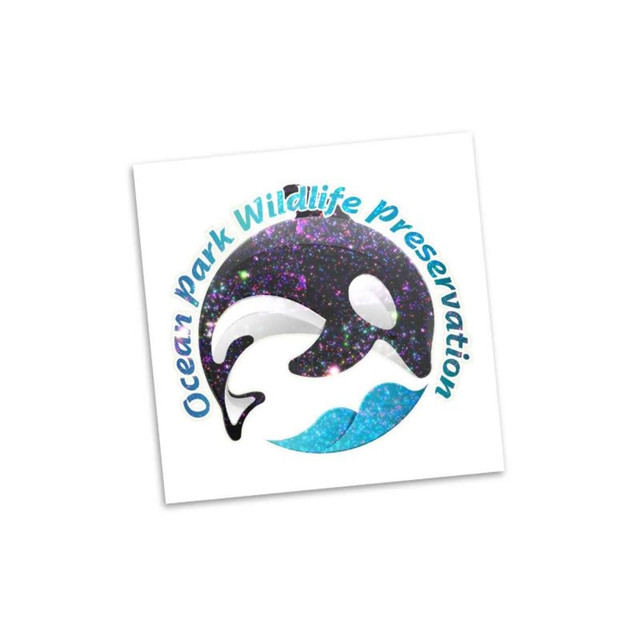 A circular logo featuring a glittery dolphin design in black and purple, with blue waves and branding around the edges.