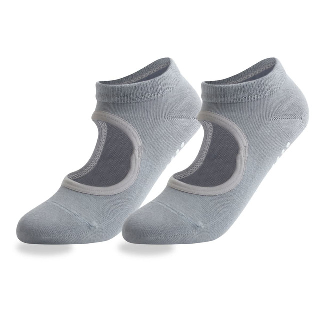 A pair of light grey open top yoga socks featuring a logo and non-slip grip on the sole.