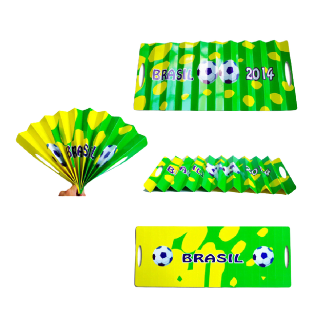 A yellow and green cardboard clapper with soccer graphics and the text "Brasil 2014," featuring a fan design.