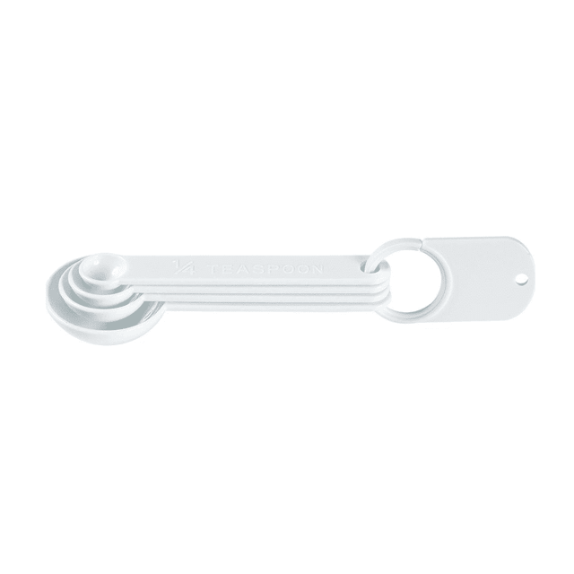 A set of four white measuring spoons, featuring different sizes, attached together with a ring.