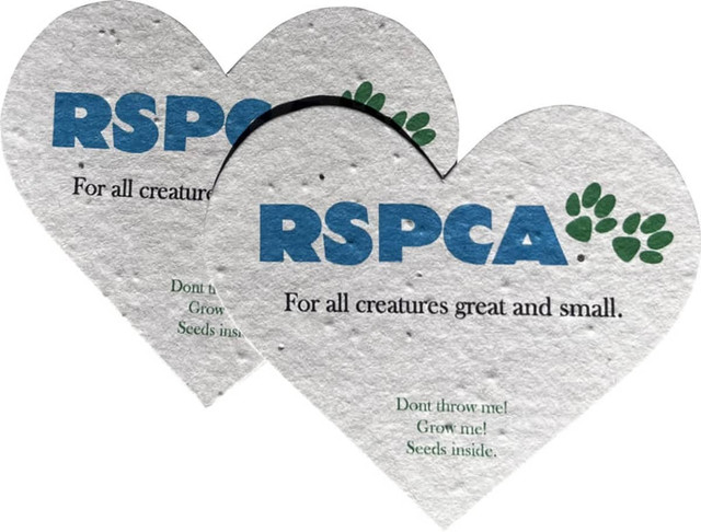 Two heart-shaped pieces of seed paper in cream, featuring a logo and text about planting seeds.