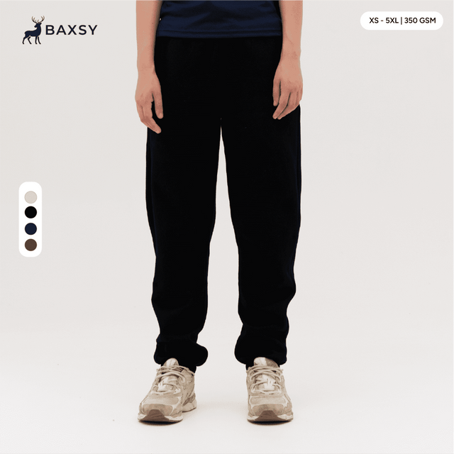 Black track pants displayed on a person, featuring a casual fit and an elastic waistband, with a logo visible.