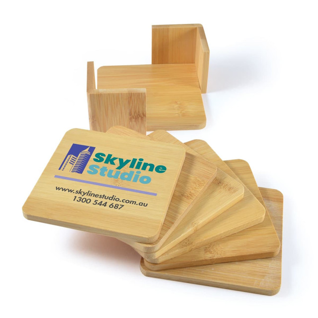 A set of six bamboo coasters with a natural finish, featuring a printed logo for "Skyline Studio" on one side.