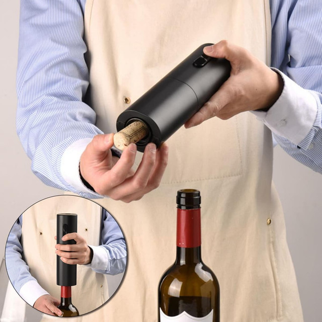 A drink bottle opener in black, designed to easily remove corks from wine bottles, held by a person in an apron.