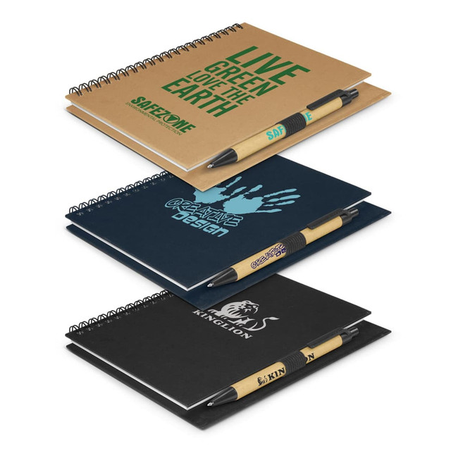Three notebooks in various colours. The top notebook is brown, the middle is blue, and the bottom is black. Each includes a pen.