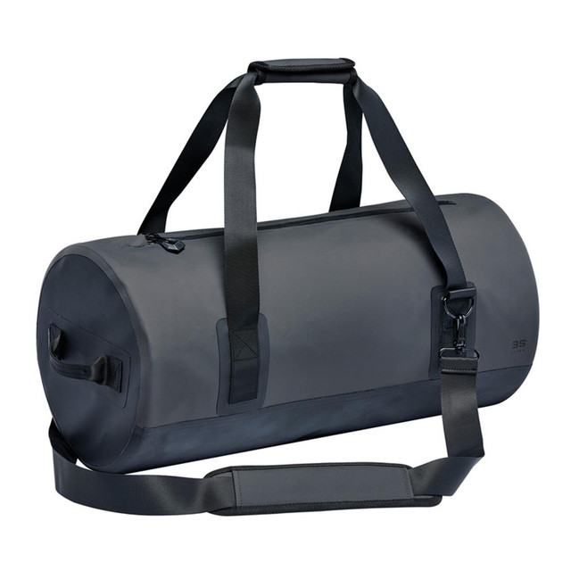 A black waterproof duffel bag with dual handles and an adjustable shoulder strap. It features a zippered opening and a logo.