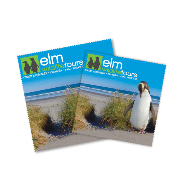 Two square cleaning cloths featuring a coastal scene with grass and a penguin, predominantly in blue and green tones.