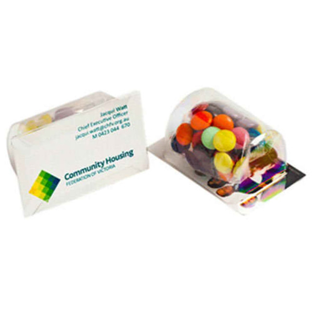A transparent package containing colourful chocolate beans, alongside a promotional card with a logo.