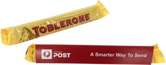A yellow Toblerone chocolate bar with a sleeve, featuring a logo and promotional text.