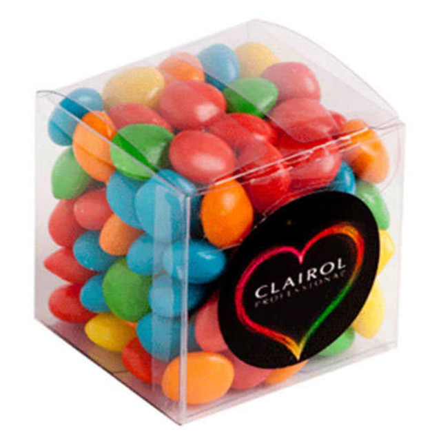 A clear cube filled with chewy fruit candies in vibrant colours: red, orange, yellow, green, and blue.