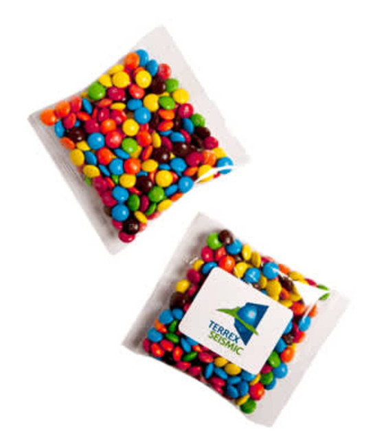 A clear packet filled with colourful Mini M&Ms in various shades, featuring a logo on one side.