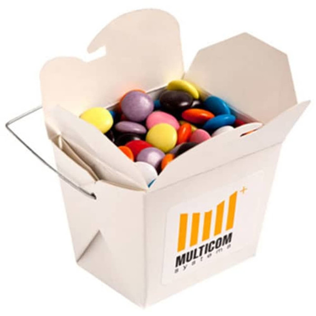 A white cardboard noodle box filled with colourful chocolate beans and featuring a logo on the side.