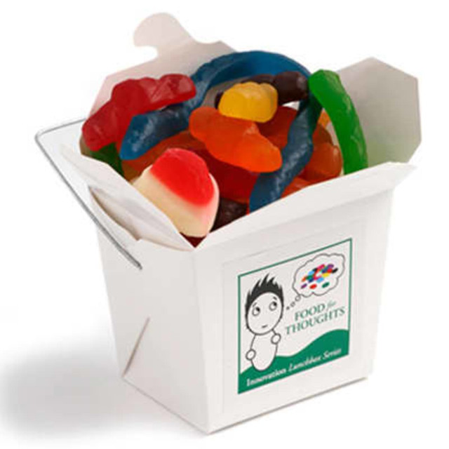 A white cardboard noodle box filled with assorted mixed lollies in various colours, including gummy worms and jelly sweets.