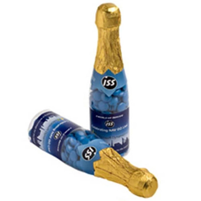 A drink bottle resembling a champagne bottle, with a gold foil top and a blue label featuring a logo, surrounded by chocolate beans.