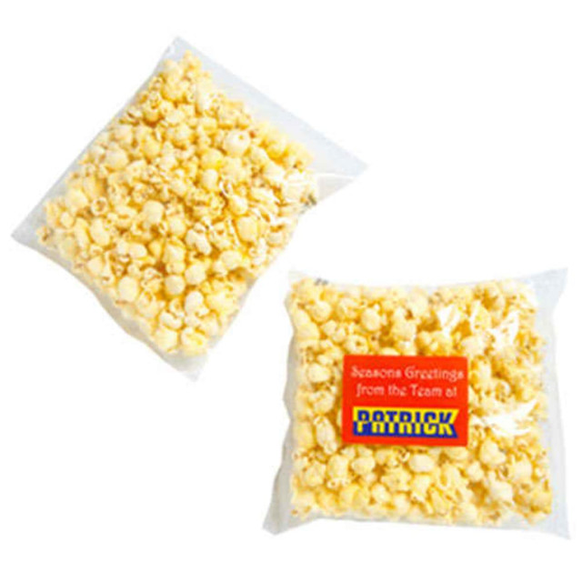 A clear bag containing yellow buttered popcorn, featuring a logo on the packaging.
