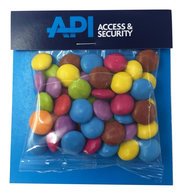 A clear bag filled with colourful Smarties in various shades, featuring a branded header.