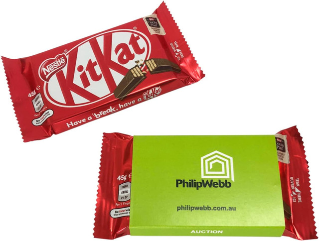 A red KitKat chocolate bar with a green sleeve packaging, featuring branding and product details.