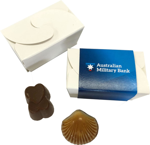 A petite white chocolate box with two assorted chocolates, one heart-shaped and one shell-shaped, featuring a logo.