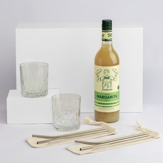 A drink bottle of Margarita with two glasses and stainless steel straws on a white background. The bottle is green and yellow.