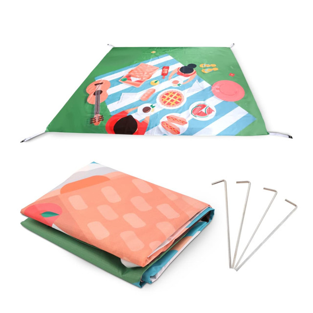 An outdoor blanket in green, featuring a picnic design, folded with pegs beside it. The size is 190x190cm.