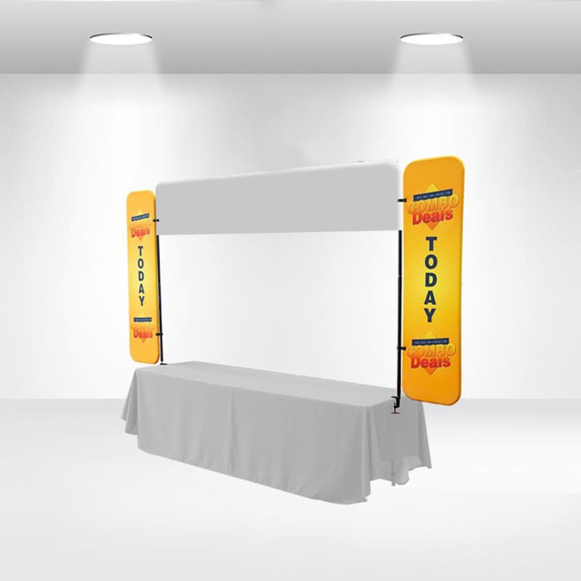 A table top banner with yellow side panels and a blank central area, set up in a bright indoor space.
