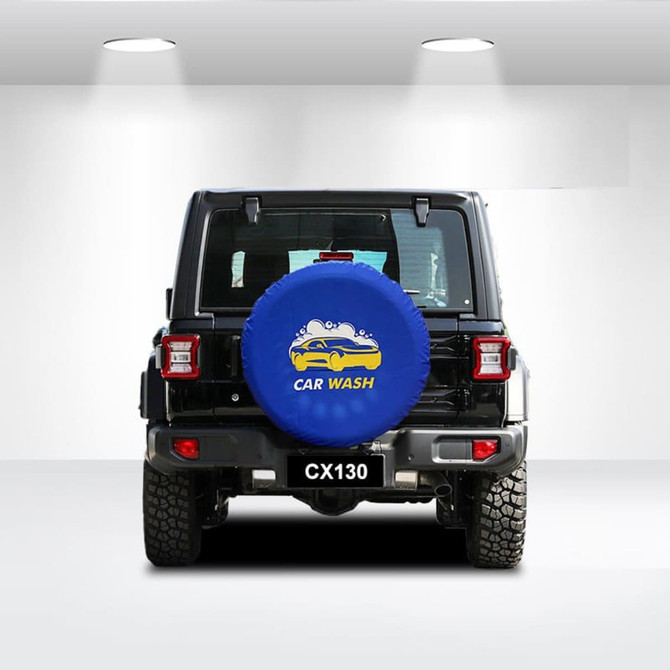 A blue spare tyre cover with a logo is fitted on the back of a black vehicle, featuring a textured surface.