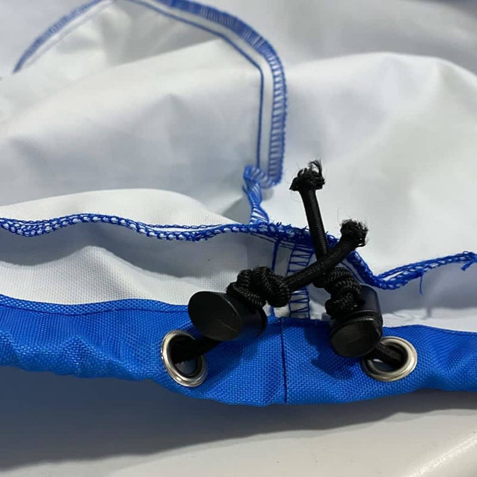 A spare tyre cover in blue and white, featuring grommets and adjustable ties for secure fitting.