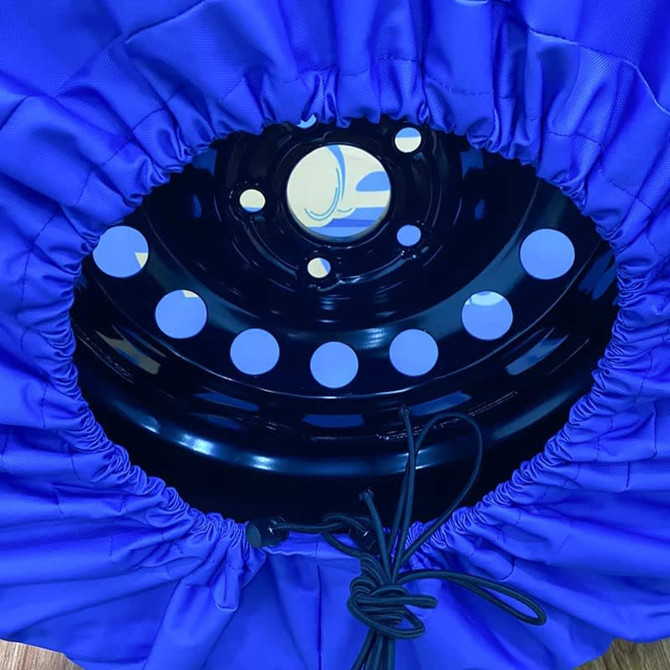 A blue spare tyre cover with a black inner ring features holes and a drawstring for securing the cover.