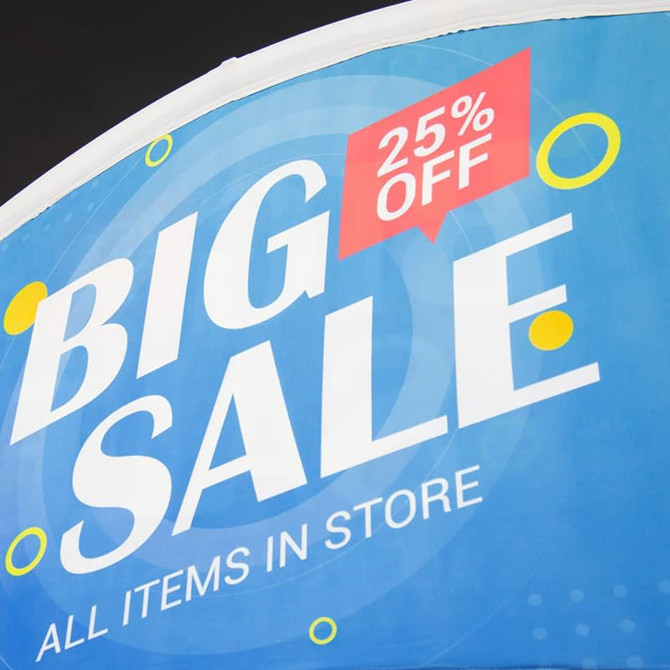 A vibrant blue tent billboard banner featuring the text "Big Sale" with a red "25% Off" highlight and circular accents.