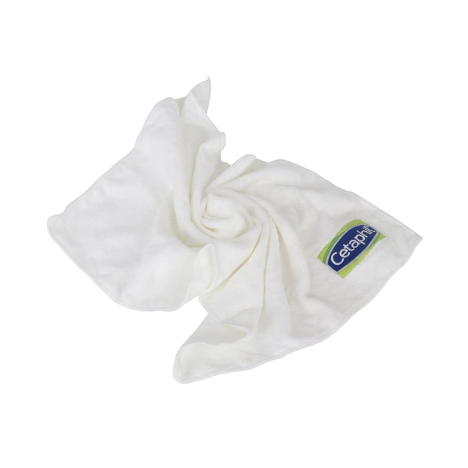 A white gym towel is folded and arranged, featuring a logo on one corner.