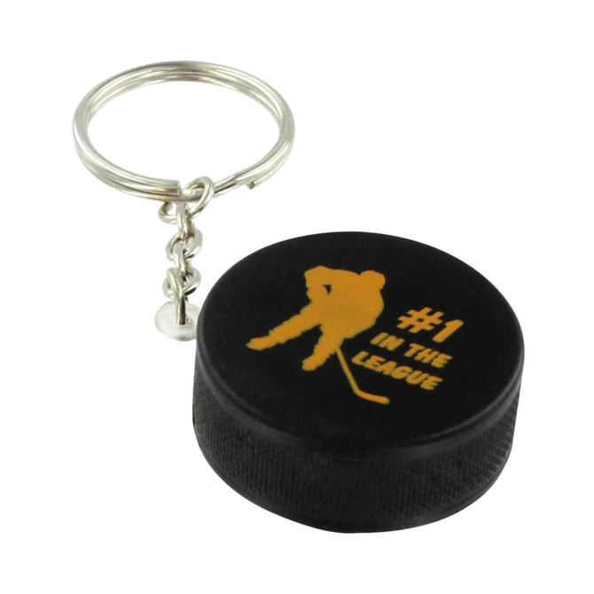 A black hockey puck stress reliever attached to a metal keyring, featuring a silhouette and gold text.