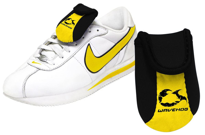 A shoe wallet in black and yellow, designed to attach to a white sneaker. It features a logo.