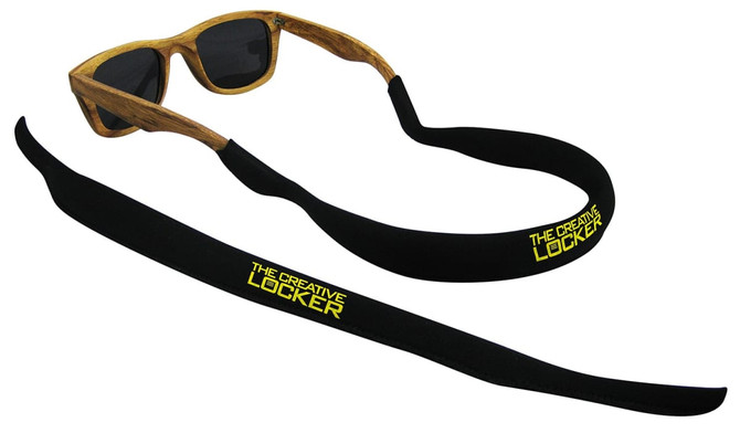 A pair of sunglasses with a black floatable strap, featuring a logo in yellow, displayed on a white background.