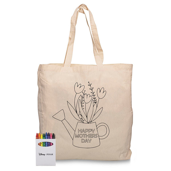 A cream tote bag featuring a floral watering can design and a crayon set in various colours.