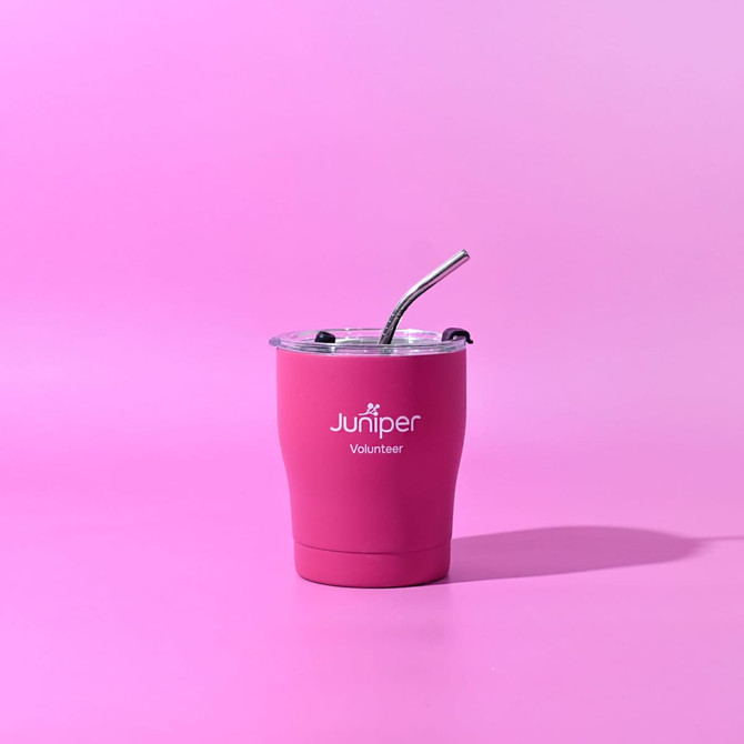 A drink bottle in vibrant pink with a clear lid and straw, featuring a logo on the front.