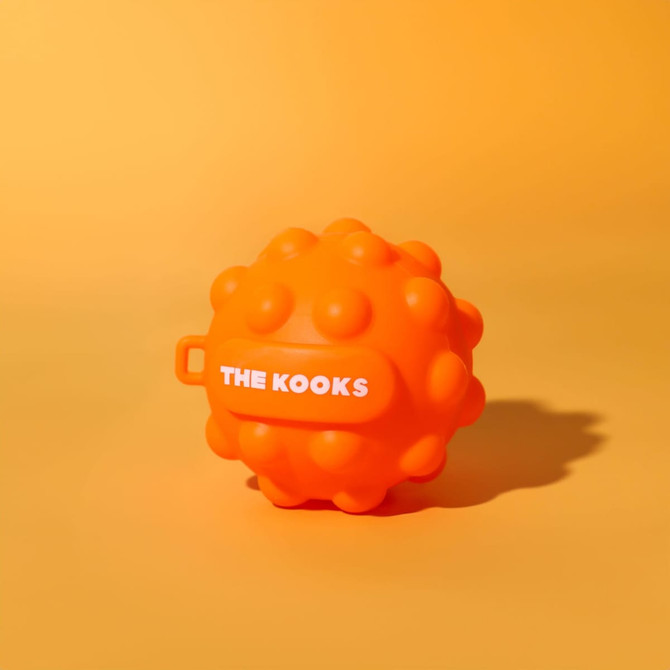 An orange stress ball with a textured surface and a handle, featuring a logo on one side.