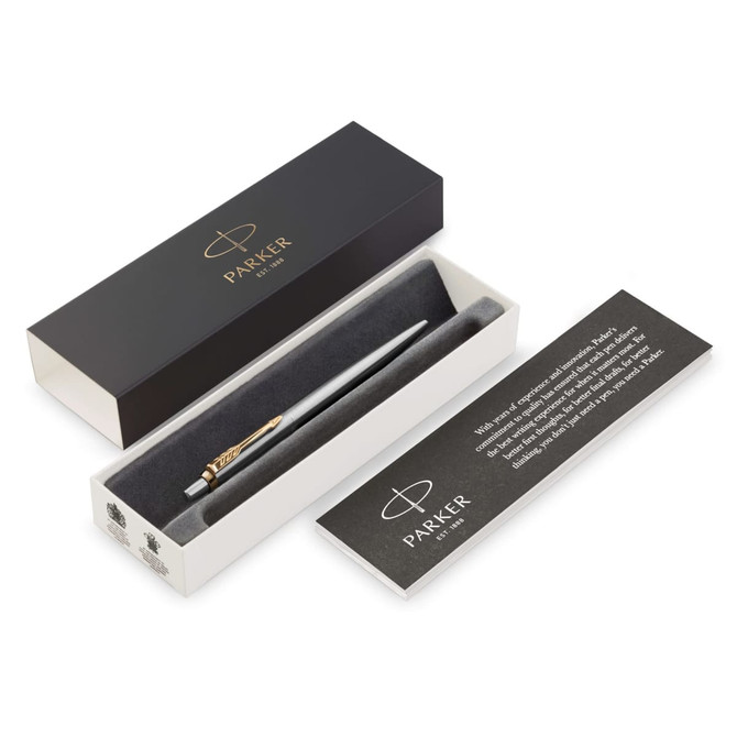 A metal ballpoint pen in brushed stainless steel with a gold-tone clip, presented in a black and white box.