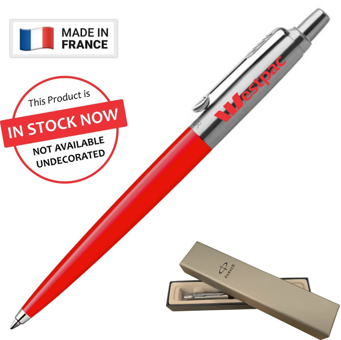 A metal ballpoint pen in red with a silver clip and branding, presented in a beige box.