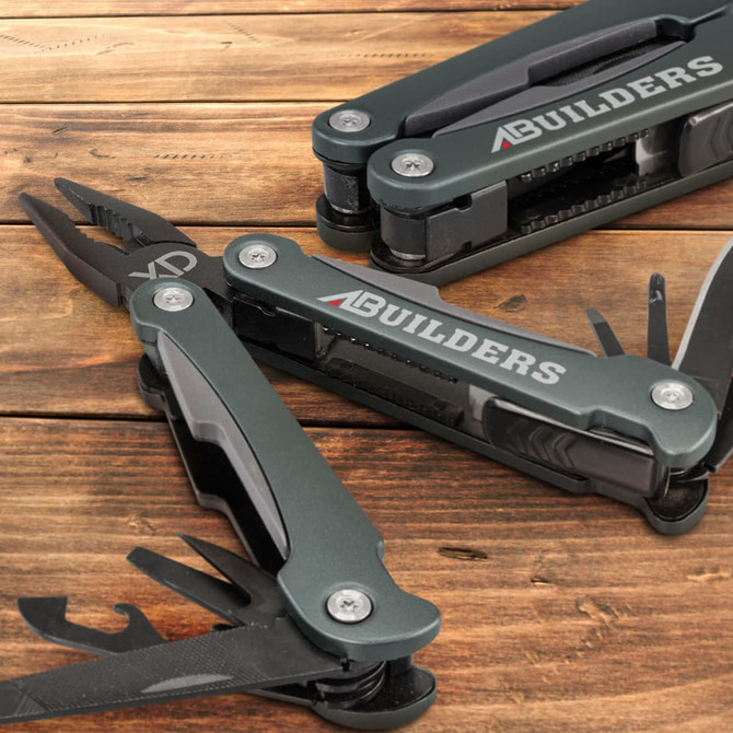 A multi-tool in dark grey with pliers, various tools, and a logo. Set against a wooden surface.
