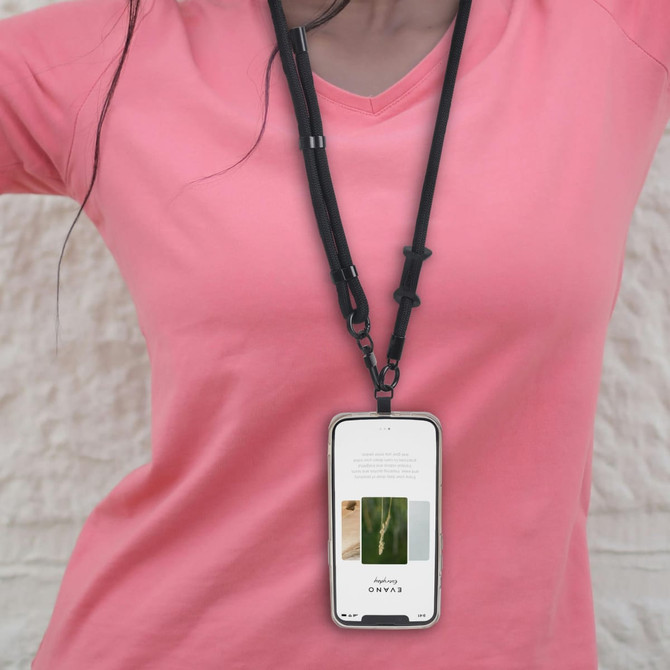 An adjustable black phone lanyard worn around the neck, holding a smartphone in front of a person wearing a pink shirt.