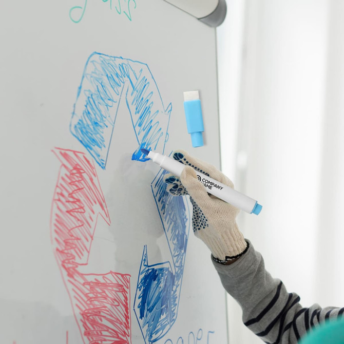 A blue magnetic whiteboard marker in use, with a gloved hand drawing on a whiteboard featuring colourful designs.