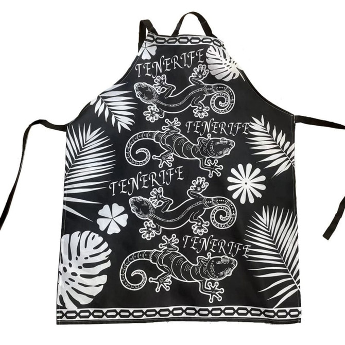 A black polyester apron featuring white lizard designs and tropical foliage patterns, complete with ties and a logo.