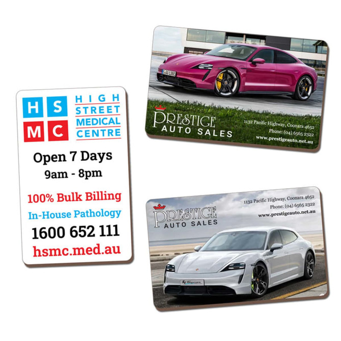 Two rectangular MDF magnets featuring a pink and a white sports car, each with a logo and brand details.