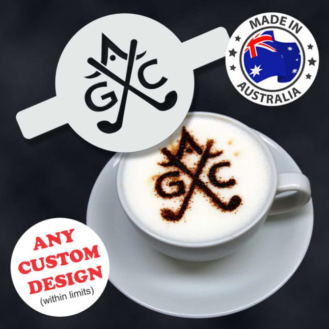 A coffee cup featuring a frothy beverage topped with a stencil pattern. The cup is white against a dark background.