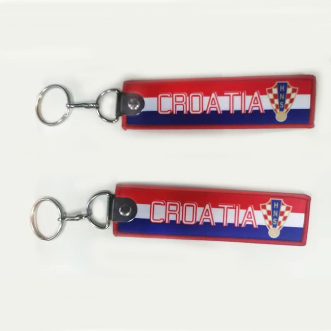 A red and blue woven keyring with the word "CROATIA" and a logo. It has a metal keychain attachment.