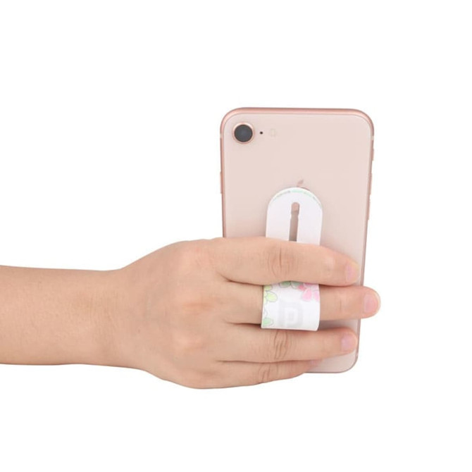 A hand holding a pink smartphone with a white push-pull phone stand attached, featuring a floral design.