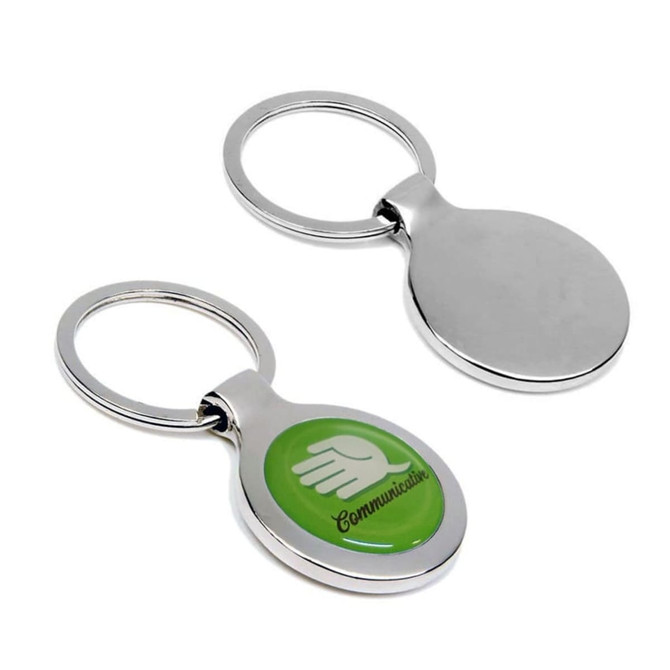 A silver metal keyring with a green circular element featuring a logo on one side and a plain back.